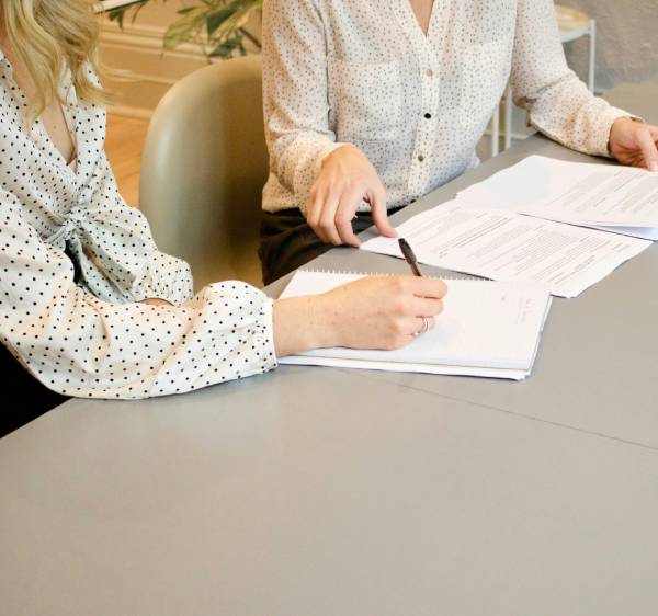 Two women reviewing documents at a table